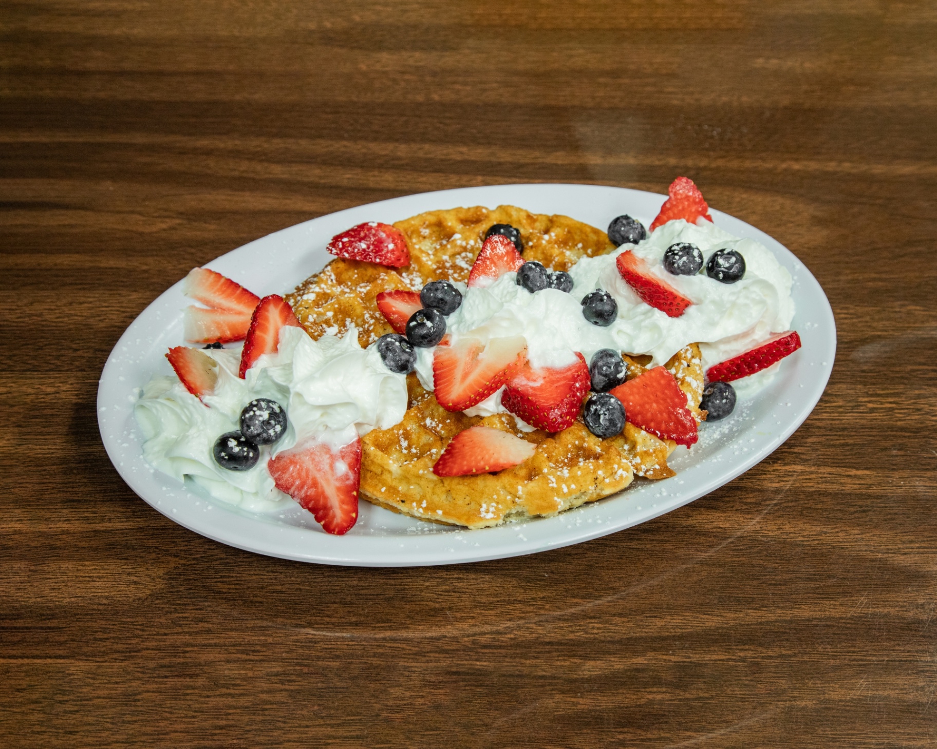 Belgian waffle with strawberries, blueberries and whipped cream